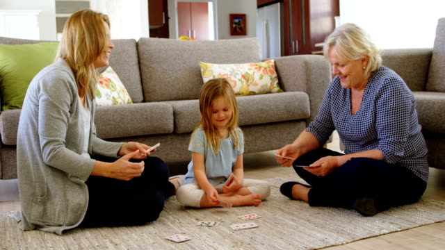 Generationsübergreifende-Familie-spielen-im-Wohnzimmer-4-k-Karten