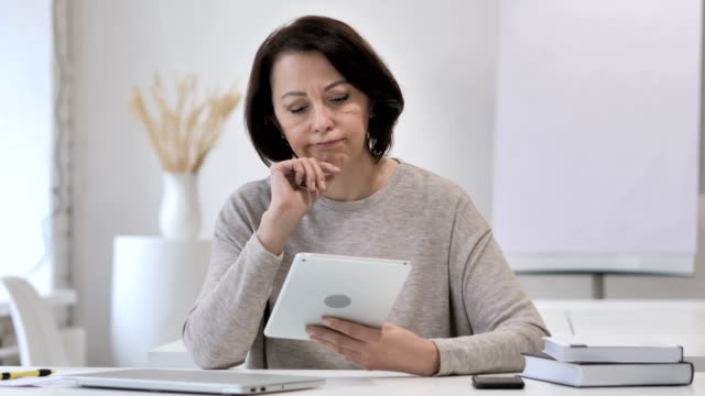 Pensativo-antigua-Senior-mujer-pensando-mientras-usando-la-tableta