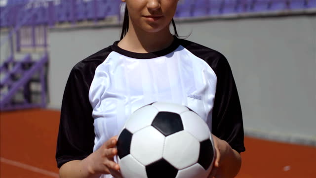 Portrait-of-young-woman-footballer-with-football-soccer-ball-on-stadium,-4k