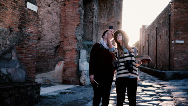 Glücklich-kaukasischen-Mutter-und-Tochter-fotografieren-Selfie-beim-erkunden-von-Alter-antiken-Straßen-von-Pompeji,-Italien-zusammen.