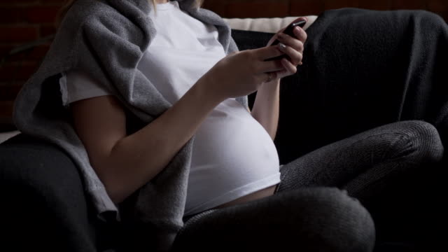 Schwangere-Frau-messaging-auf-dem-Handy