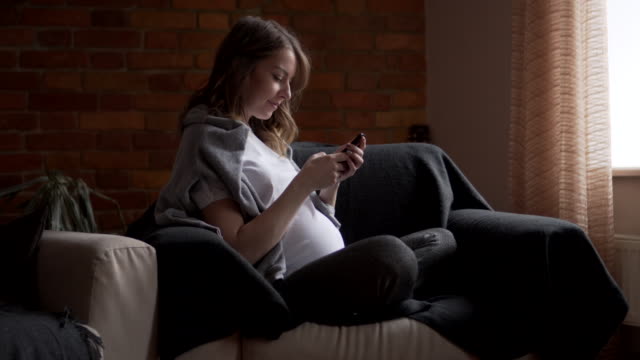 Schwangere-Frau-messaging-auf-dem-Handy