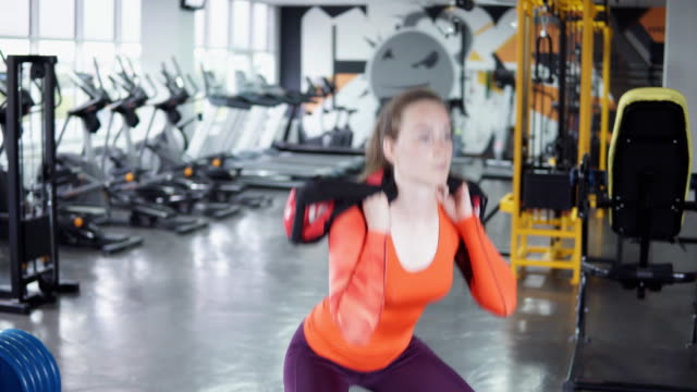 Young-beautiful-girl-doing-squats-in-the-gym,-4k.-Concept-of-sport-and-healthy-lifestyle