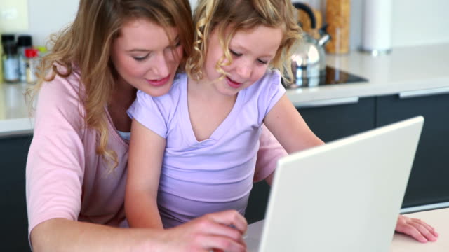 Madre-e-hija-usando-la-computadora-portátil-juntos