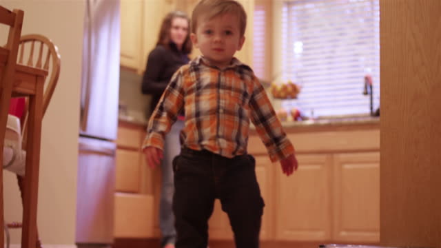 A-little-boy-walking-through-the-kitchen-and-living-room-to-play-with-his-toys