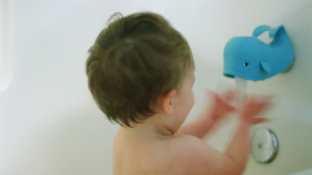 Adorable-little-boy-sits-in-the-bathtub-as-the-water-fills-up