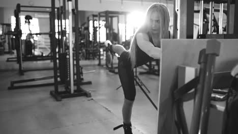 Strong-blonde-woman-doing-exercise-wtiht-lifting-weights-in-fitnest-club