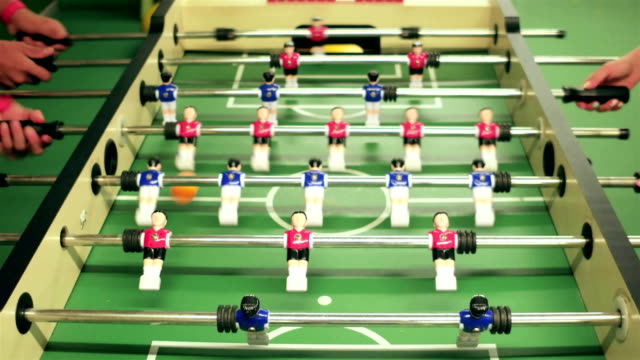 Spielen-Sie-Tischfußball,-Nahaufnahme-von-Menschen-spielen-Tabelle-Fußball,-blau-und-rot-Kunststoff-Figuren