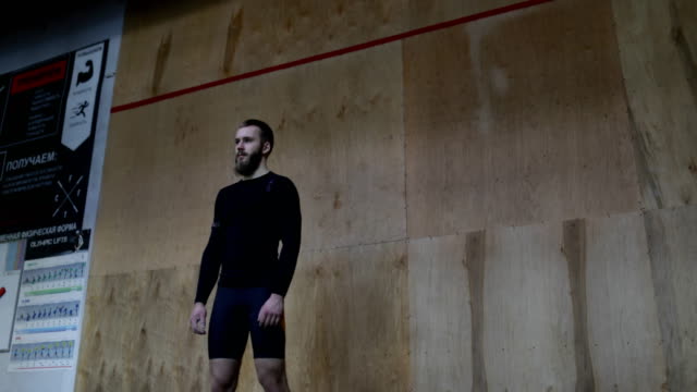 Muskulöser-Mann-Sportler-Portrait-vor-Wand-im-Sportverein-vor