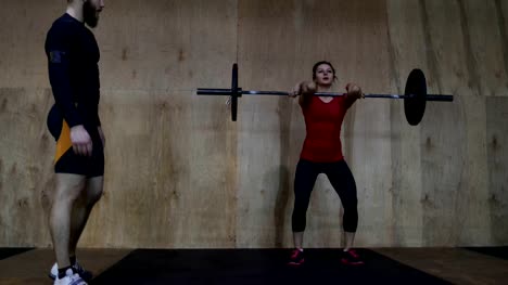 Mujer-atlética,-levantamiento-de-pesas-trabajando-con-Entrenador-Personal-en-gimnasio