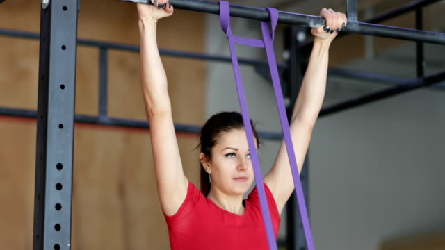 Woman-Hanging-On-Bar-Doing-Pulling-Up-Exercise-During-Workout-Training-At-Gym