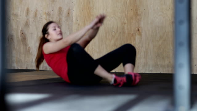 Junge-Frau-Abs-sitzt-Ups-Übung-beim-Workout-Training-im-Fitness-Studio-trainieren
