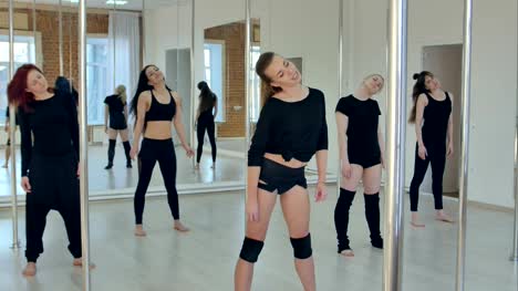 Attraktive-Sport-Mädchen-dehnen-vor-dem-Pole-Dance-Klasse-im-Fitnessraum-mit-windows