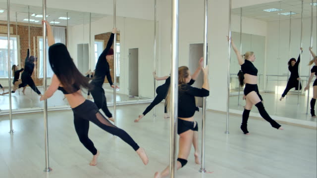 Gruppe-von-hispanischen-Frauen-dehnen-und-Aufwärmen-für-ihre-Pole-Dance-Klasse