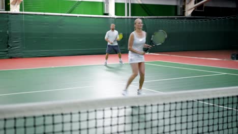 Männliche-und-weibliche-Tennis-Team-Spiel-auf-Platz