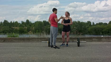 Smiling-sporty-couple-talking-after-work-out-outdoors-on-city-street