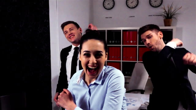 Crazy-happy-businessmen-and-businesswoman-dancing-in-office