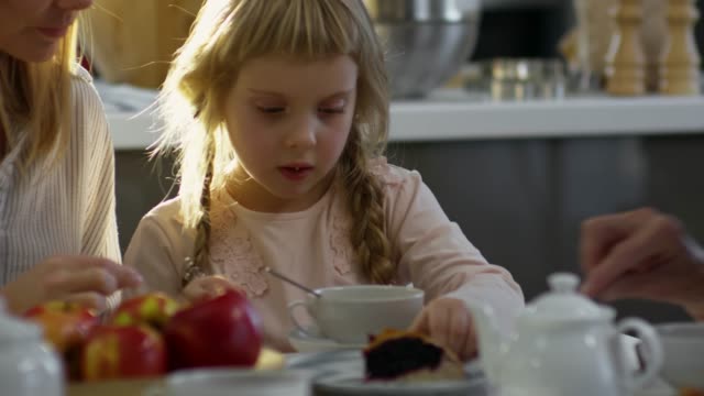 Little-Girl-Enjoying-Sweet-Pie-at-Family-Dinner