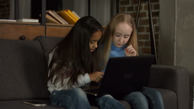 Diversos-niños-navegando-por-la-red-en-la-computadora-portátil-en-casa