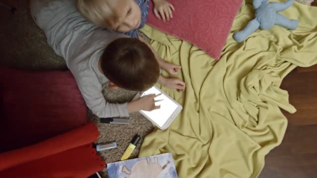 Kinder-Zeichnung-auf-Tablet-unter-handgemachte-Spielzelt
