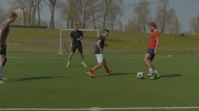 Football-players-training-on-soccer-field-in-spring
