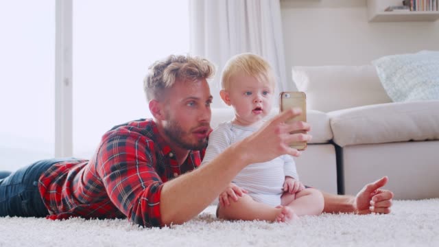 Papa-liegt-auf-Boden-zu-Hause-nehmen-Selfies-mit-kleinen-Sohn