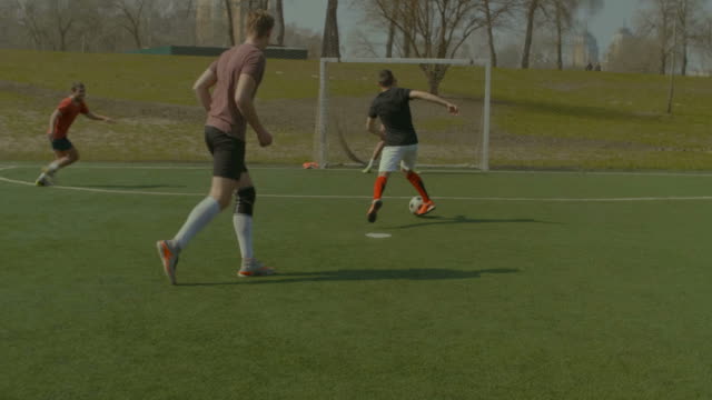 Football-player-tackling-for-ball-against-striker