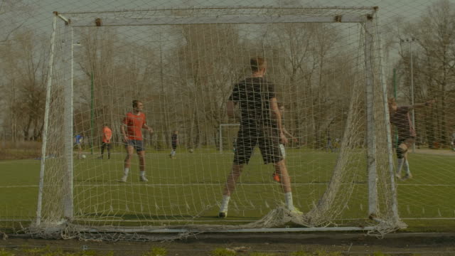 Striker-taking-a-shot-on-goal-during-football-match