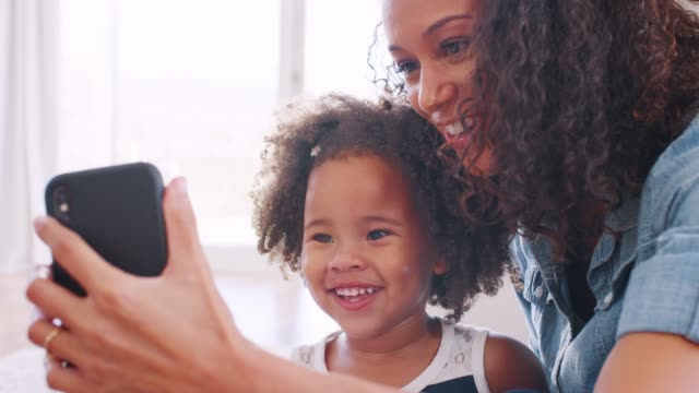 Junge-schwarze-Frau,-die-ihr-Kleinkind-Tochter-Selfie-mitnehmen