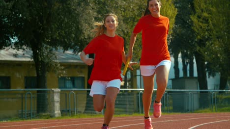 Athletes-pass-the-baton-in-a-track-relay.-shot-in-super-slow-motion
