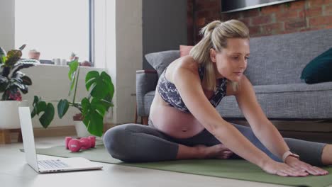 Mujer-embarazada-activa-viendo-videos-de-ejercicio-prenatal-online
