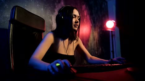 Professional-Girl-Gamer-Plays-in-MMORPG-or-Strategy-Video-Game-on-Her-Computer.-She's-Participating-in-Online-Cyber-Games-Tournament,-Plays-at-Home,-or-in-Internet-Cafe.-She-Wears-Gaming-Headset