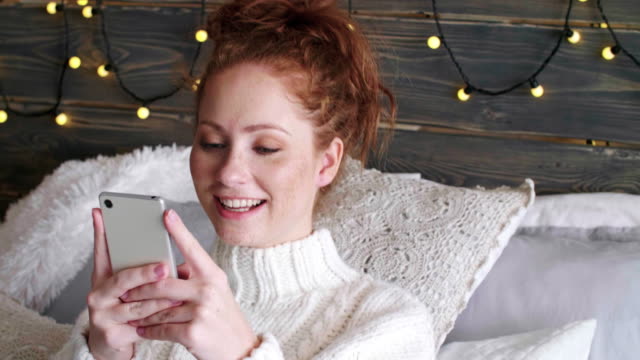 Girl-with-mobile-phone-spending-christmas-time-in-bed