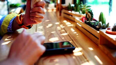 Frau-Hand-mit-Smartphone-im-Café-Hintergrund.-Geschäftlichen,-finanziellen,-Handel-Lager-Maket-und-soziale-Netzwerk-Konzept.