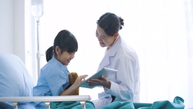 Ärztin-zeigen-digitale-Tablet-Computer-und-im-Gespräch-mit-Patienten-Mädchen-glücklich-Rührung.