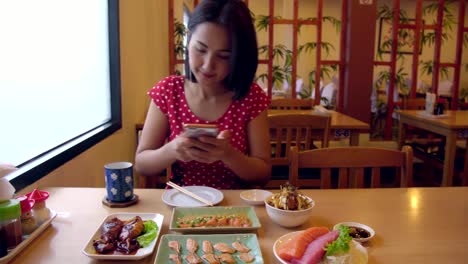 Young-Asian-Woman-Taking-Photo-and-Selfie-with-Salmon,-Chicken,-Sashimi-Japanese-Food.