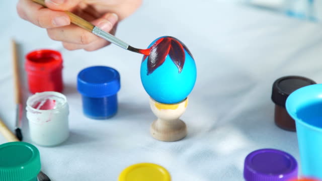 Mujer-mano-pintura-huevos-de-Pascua-con-el-pincel