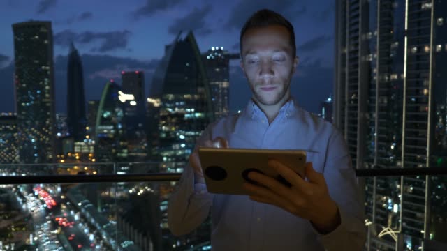 Junger-Mann-mit-Tablet-zu-sprechen-und-mit-Wolkenkratzer-Ansicht-Hintergrund-kommunizieren