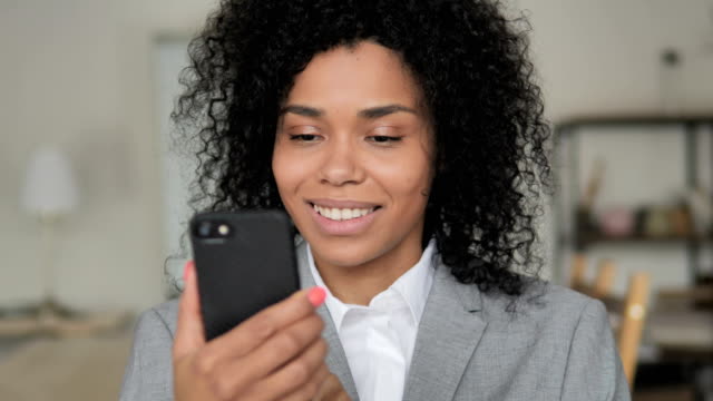 Mujer-empresaria-africana-usando-smartphone,-mensajería-de-texto