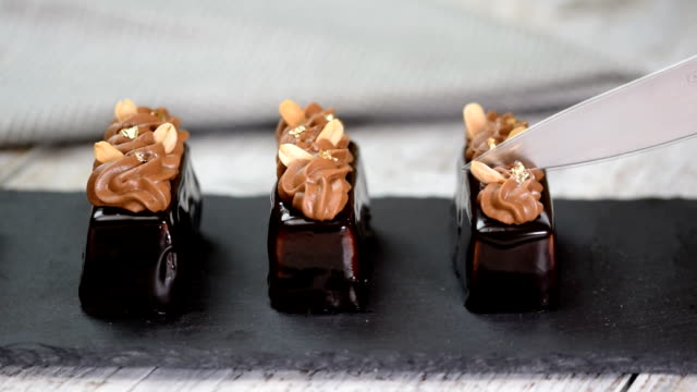 Mini-mousse-pastry-dessert-covered-with-chocolate-glaze-and-peanuts.-Modern-European-cake.-French-cuisine.