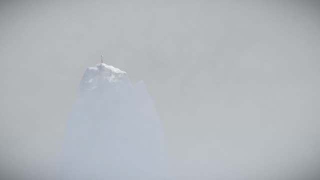 Niña-abandonada-sosteniendo-globos-en-la-cima-de-una-montaña-cubierta-de-nieve,-vista-de-drones,-4K