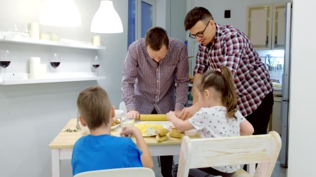 Schwule-Familie-mit-zwei-Kindern-kocht-Pizza-in-der-Küche.