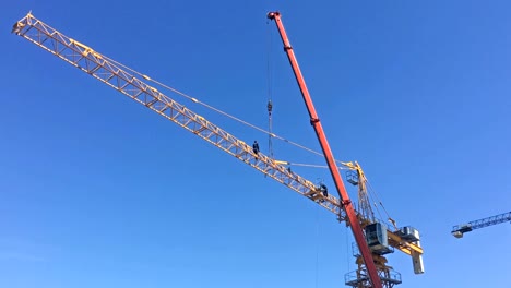 Trabajador-instalando-plumón-en-una-grúa-de-construcción