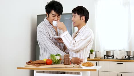 Happiness-gay-couple-preparing-food-at-the-kitchen-in-the-morning-and--have-a-breakfast.