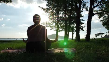 Asian-women-practicing-yoga-relax-in-nature-in-the-evening-sunlight,-Lotus-pose-on-meditation-session.-Fitness-and-healthy-lifestyle-concept.-Slow-motion