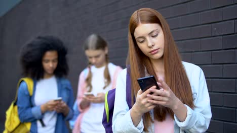 Addicted-female-teenagers-reading-social-networks-comments-using-smartphones