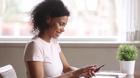 Sonriendo-mujer-afroamericana-usando-la-aplicación-de-citas-de-teléfonos-inteligentes-deslizando