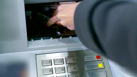 closeup-ATM-slot-cover-opens-woman-puts-banknote-backwards