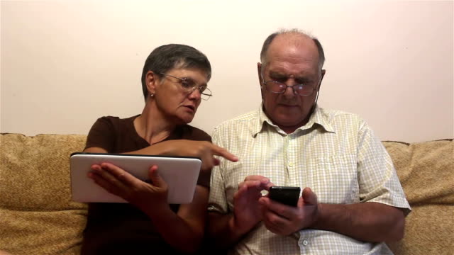 Attraktive-erwachsene-Frau-und-erwachsene-Mann-arbeiten-auf-Tablet-PC-und-Smartphone.