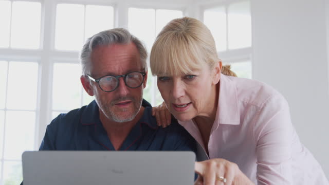Senior-Paar-mit-Mann-im-Rollstuhl-suchen-Informationen-über-Medikamente-online-mit-Laptop
